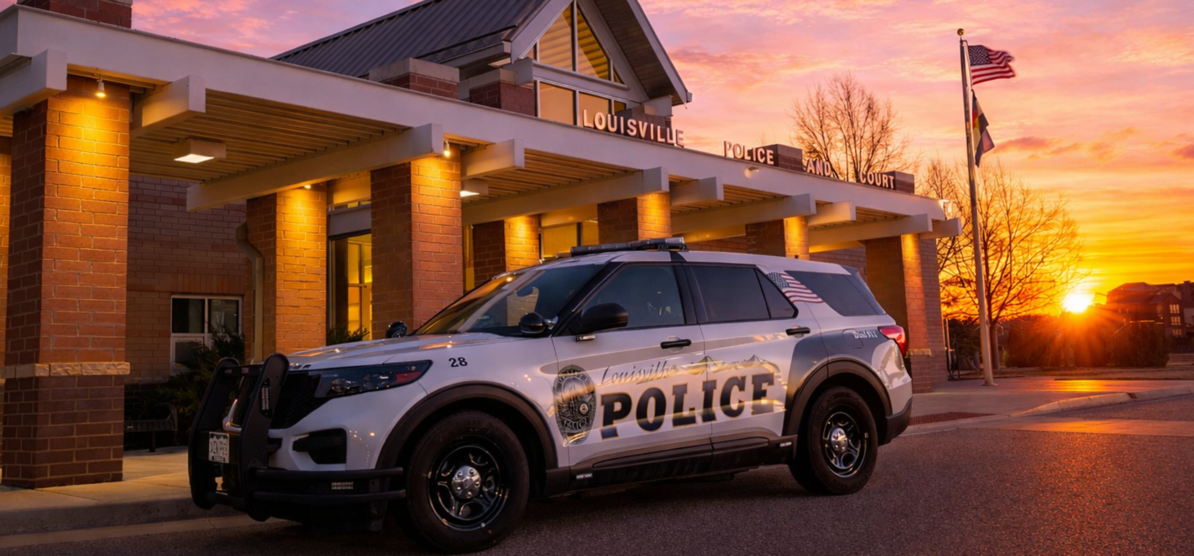 Louisville Police Department car outside a building in the evening.