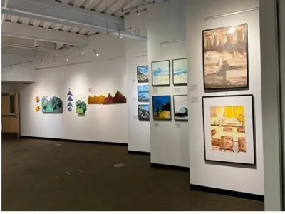 A gallery wall hung with a group of paintings.