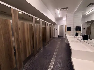 Recreation center family locker room with wooden lockers and benches.
