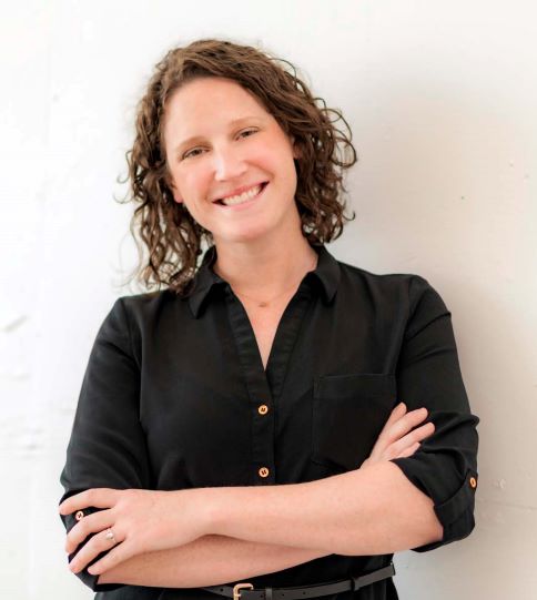 Headshot of a woman wearing a black shirt in front of a white background.