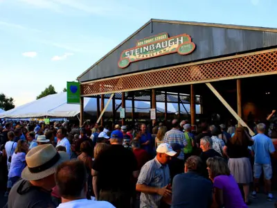A group of people at a pavilion outside in the evening.