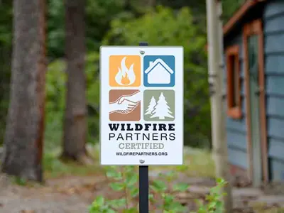 wildfire partners sign with logo in front of a wooded area