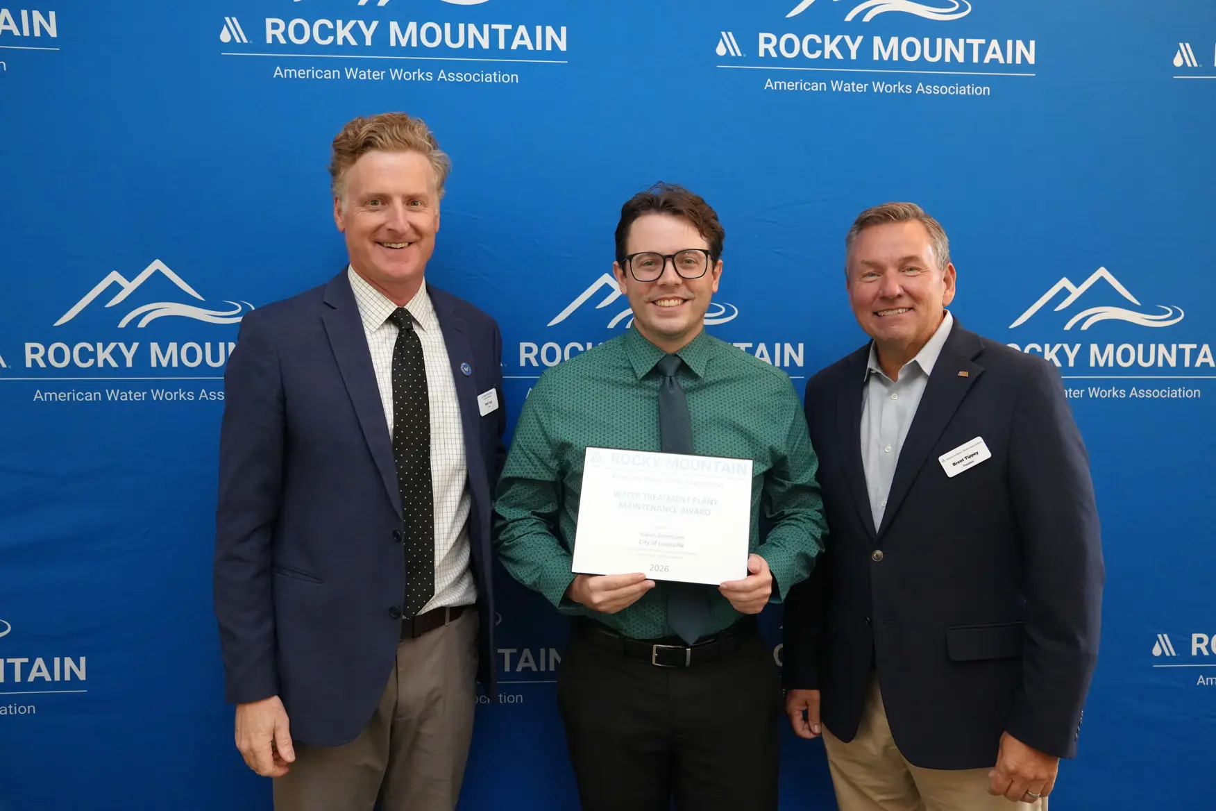 Louisville water treatment plant operator Isaiah Biermann holds award with officials at the 2026 Rocky Mountain Water Conference