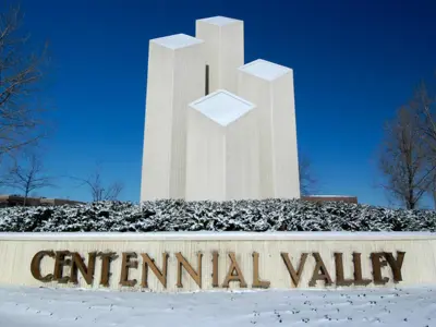 A stone sign and monument reading Centennial Valley.