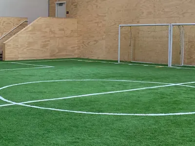 Indoor turf field with soccer goals and field markings.