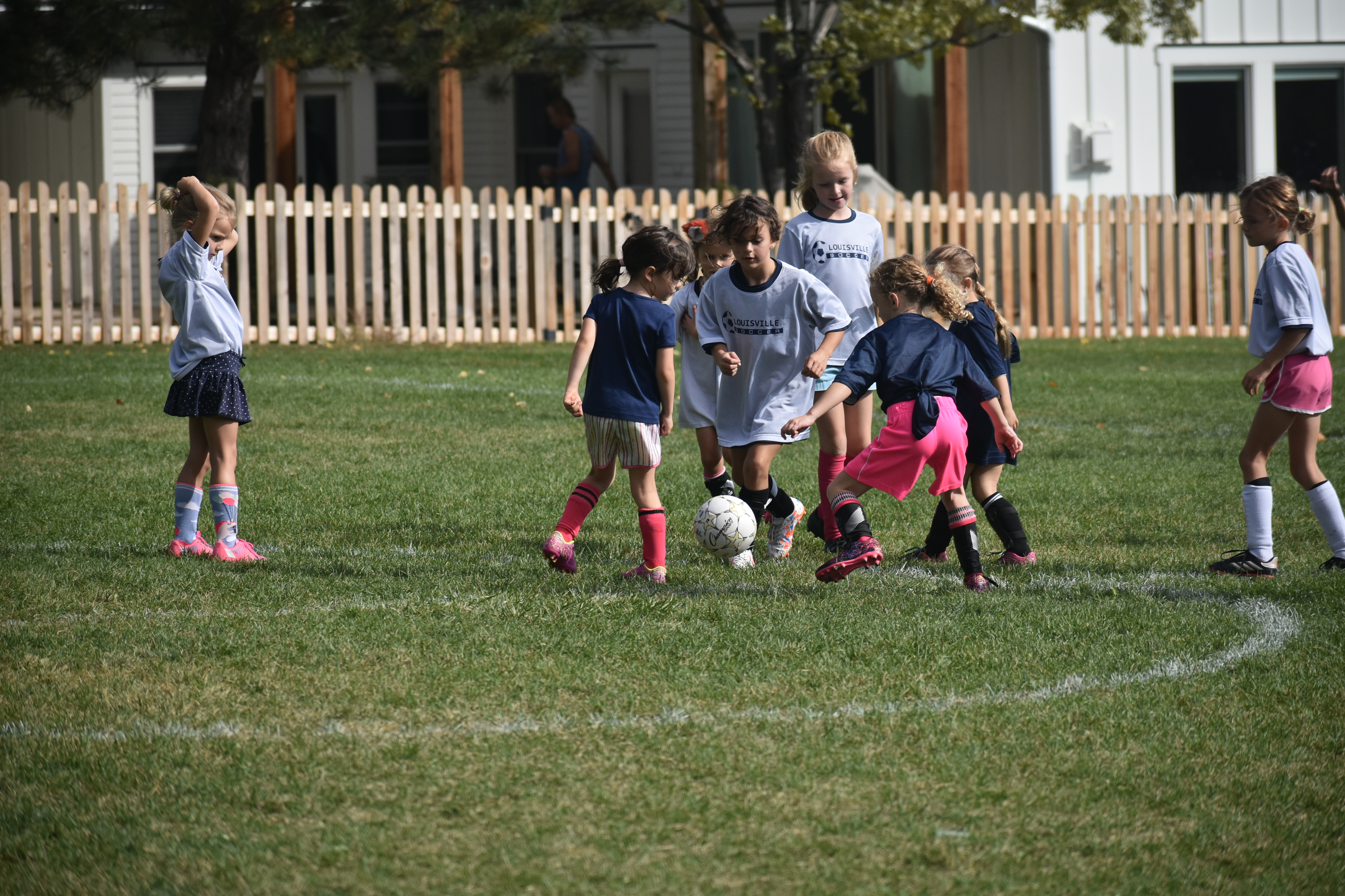 Children practicing soccer on a grassy field.